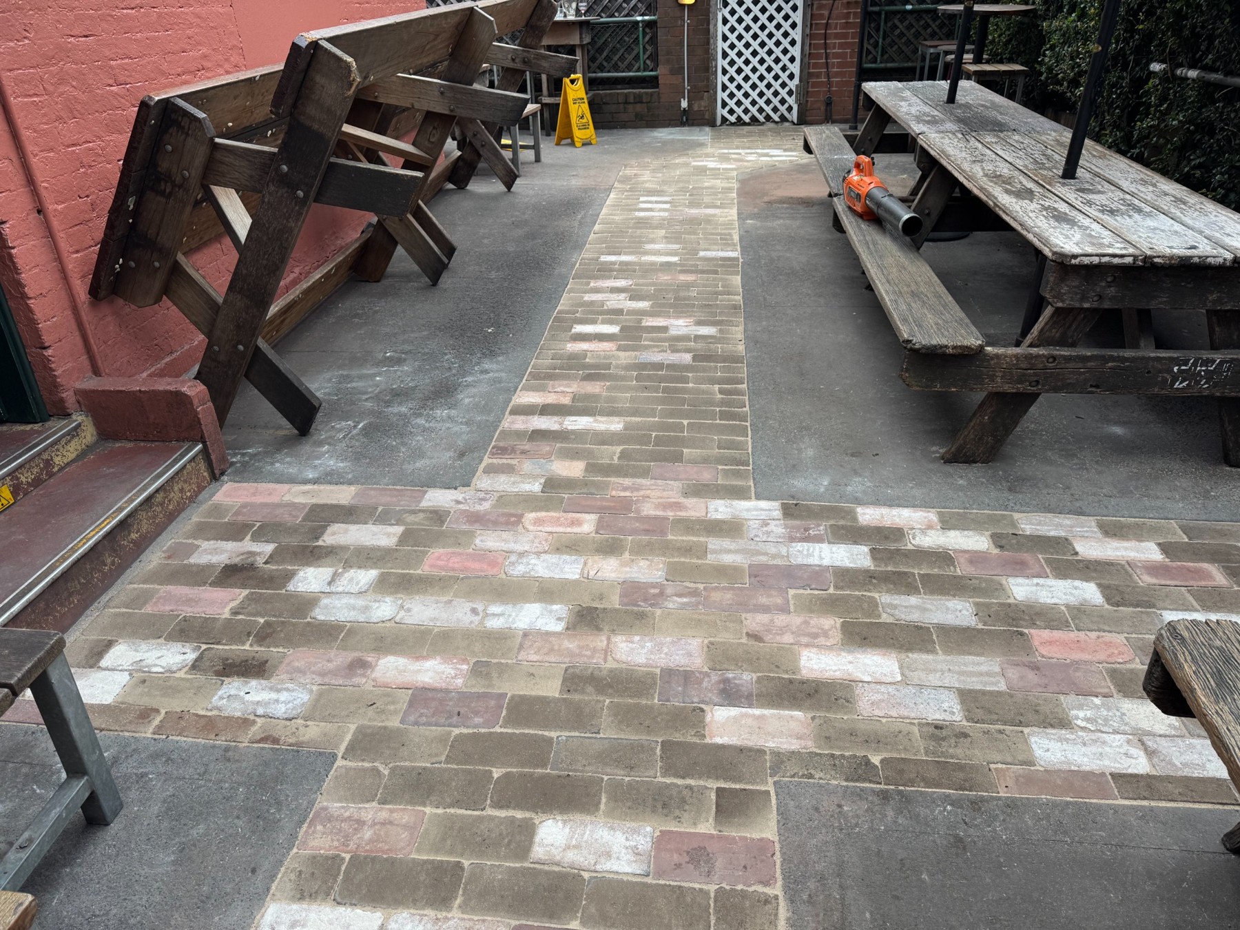 Recycled brick paving through a commercial courtyard with timber seating