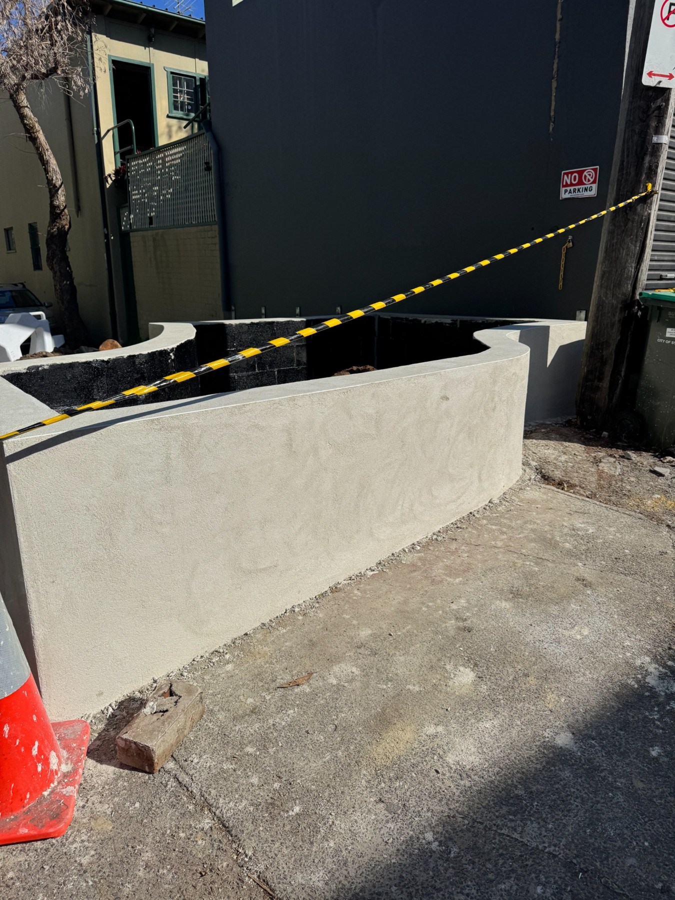 Side view of the rendered curved planter wall during construction
